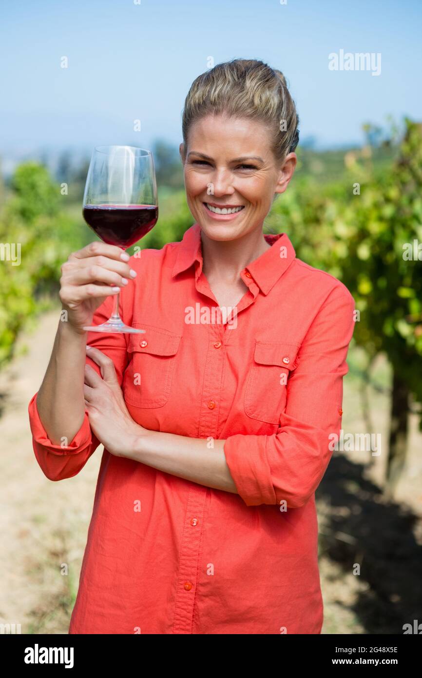 Portrait of female vintner holding glass of wine Stock Photo - Alamy