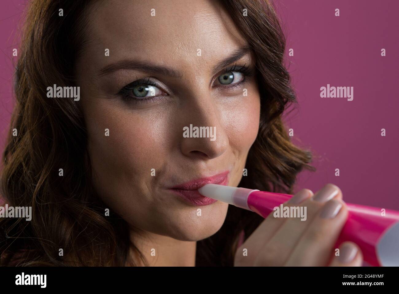 Woman in sliver hat blowing party horns Stock Photo - Alamy