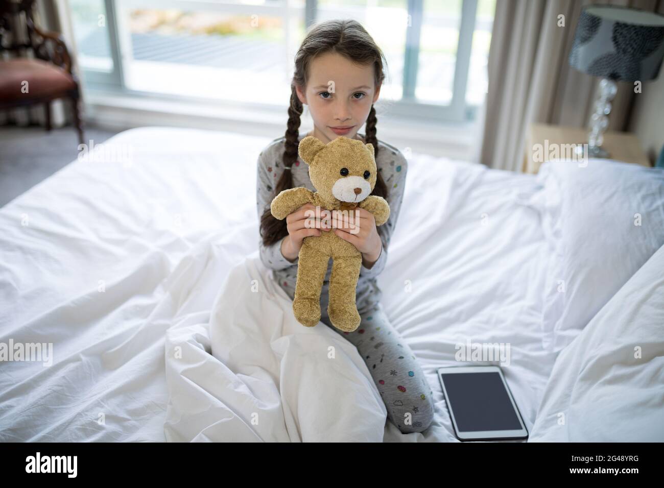 Girl holding teddy bear on bed in bedroom Stock Photo - Alamy