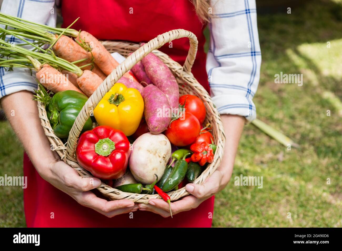 Woman holding a basket of fresh vegetables at stall Stock Photo - Alamy