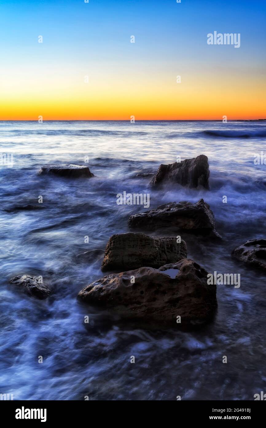 Sandstone rocks on the Pacific ocean coast of Sydney - Newport Northern beaches at sunrise. Stock Photo