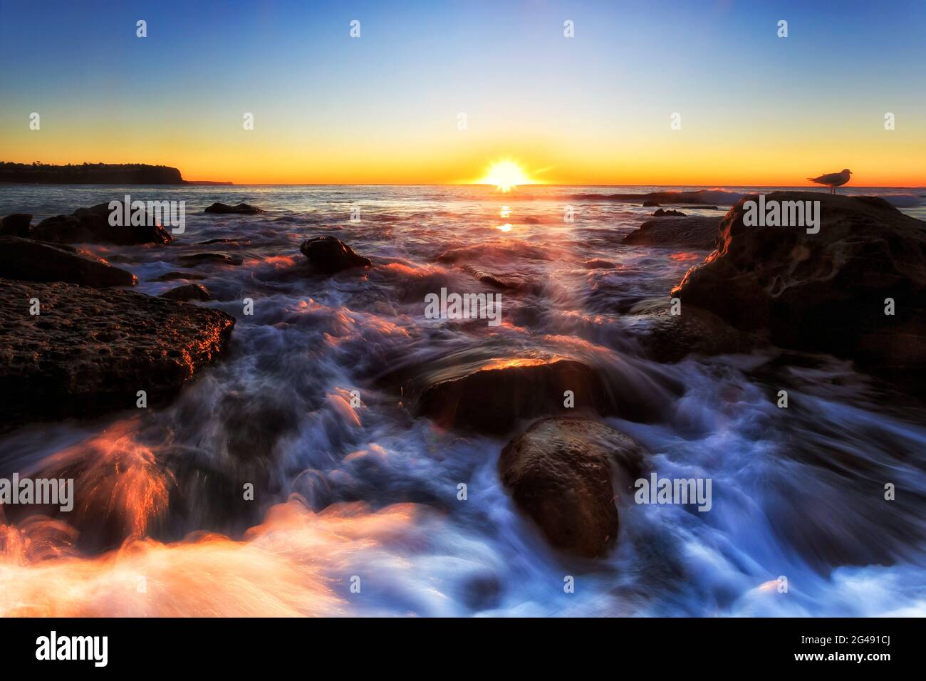 Scenic seascape sunrise of hot rising sun over Pacific ocean horizon off Newport beach in Sydney. Stock Photo