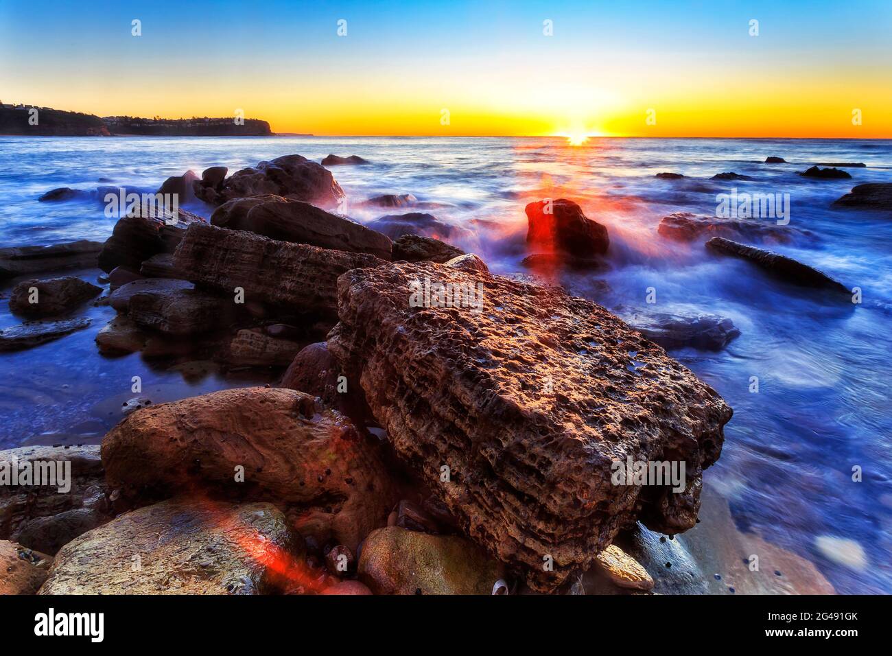 Rising Sun across horizon off Newport beach in Sydney - Pacific ocean coast. Stock Photo