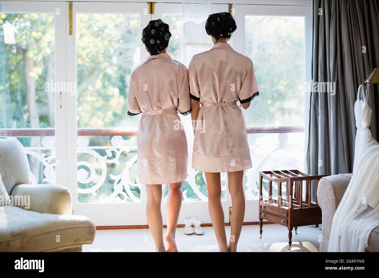Rear view of women standing near window Stock Photo - Alamy