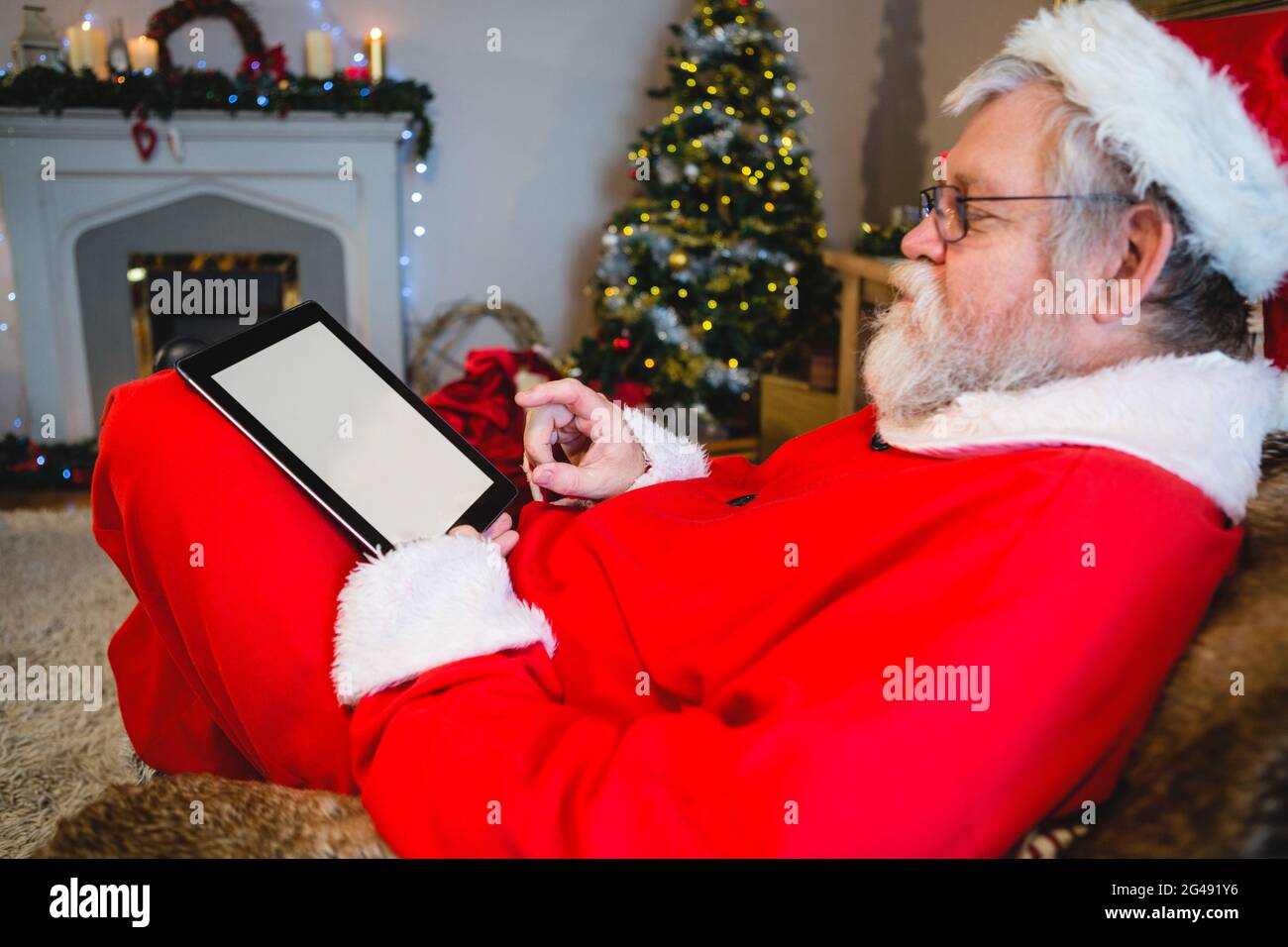 Santa Claus using digital tablet Stock Photo - Alamy
