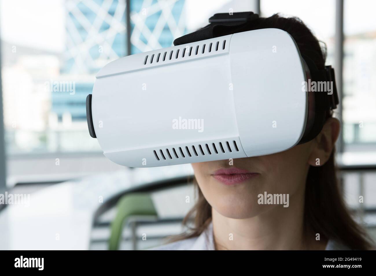 Female executive using virtual reality headset Stock Photo - Alamy