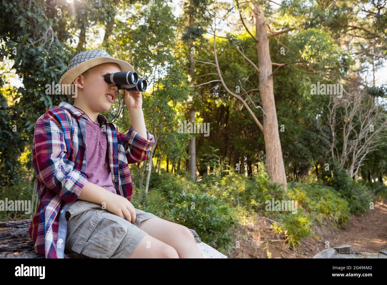 Boy looking through binoculars in the forest Stock Photo Alamy