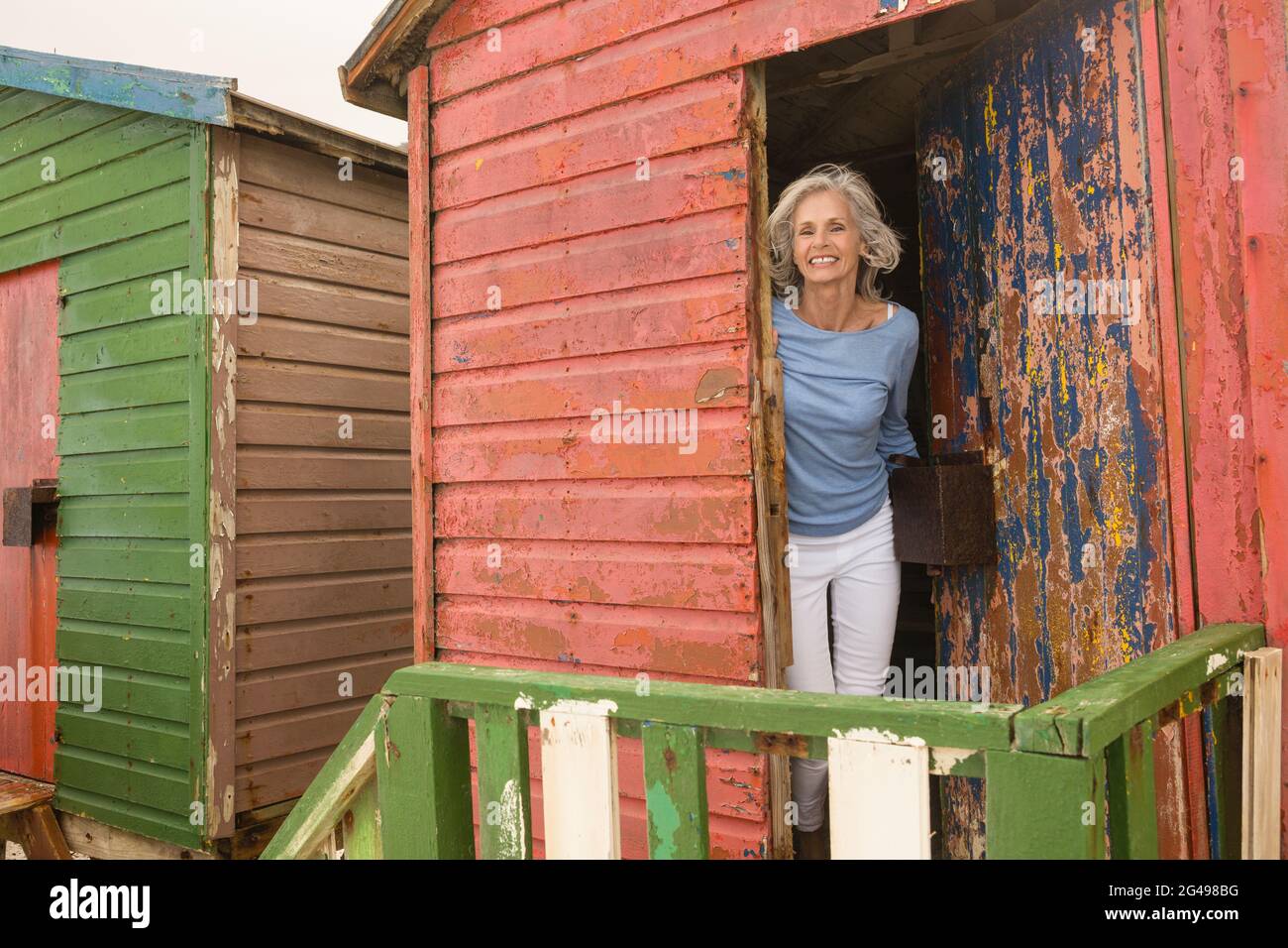 Portrait of smiling senior woman standing at beach hut Stock Photo - Alamy