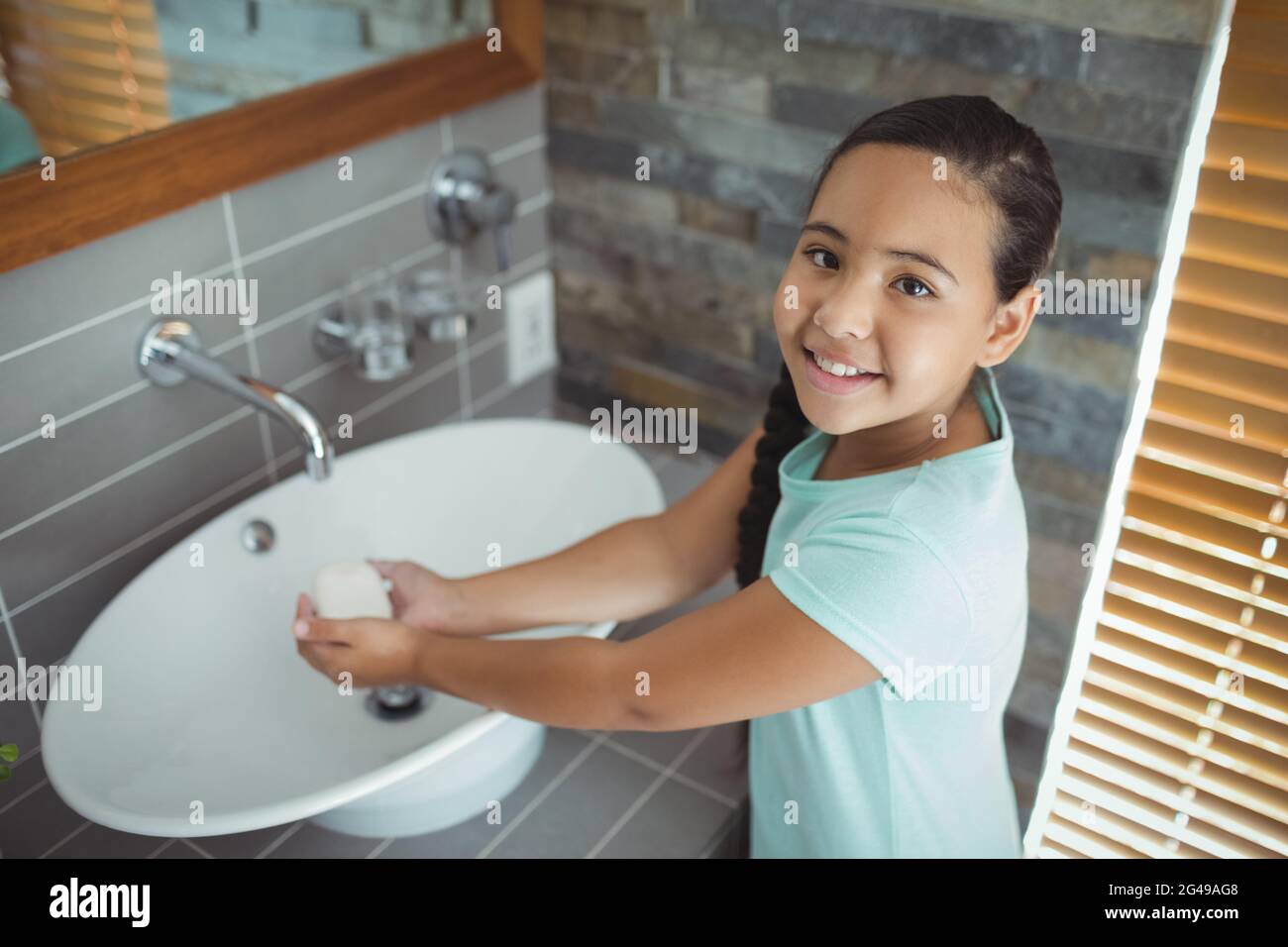 Girl washing hands in bathroom sink Stock Photo - Alamy