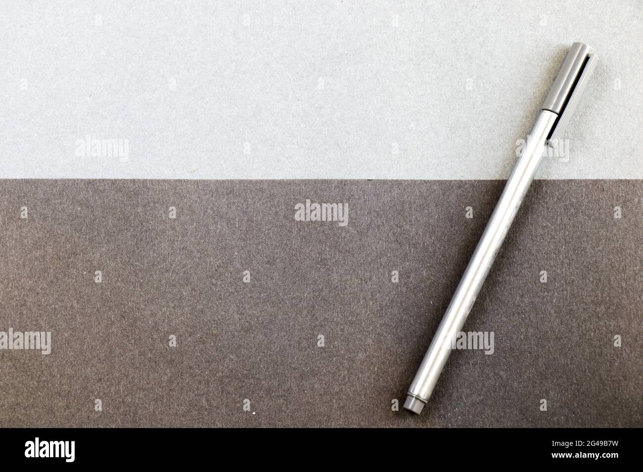 A gray pen on the black and gray papers background for a copy space Stock Photo