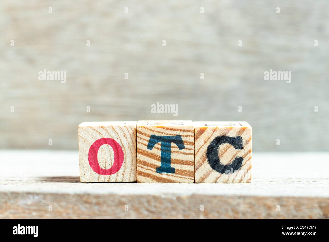 Alphabet letter block in word OTC (Abbreviation of over the counter) on wood background Stock Photo