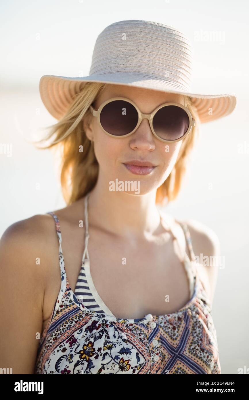 Young woman wearing sunglasses standing beach hi-res stock photography ...