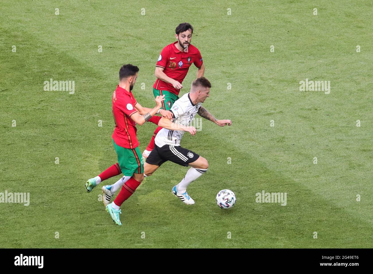 Munich, Germany. 19th June, 2021. Toni Kroos (bottom R) of Germany breaks through the defense from Bruno Fernandes (bottom L) and Bernardo Silva of Portugal during the UEFA Euro 2020 Championship Group F match in Munich, Germany, June 19, 2021. Credit: Shan Yuqi/Xinhua/Alamy Live News Stock Photo