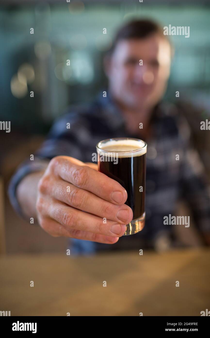 Close up of man holding beer glass at bar counter Stock Photo - Alamy
