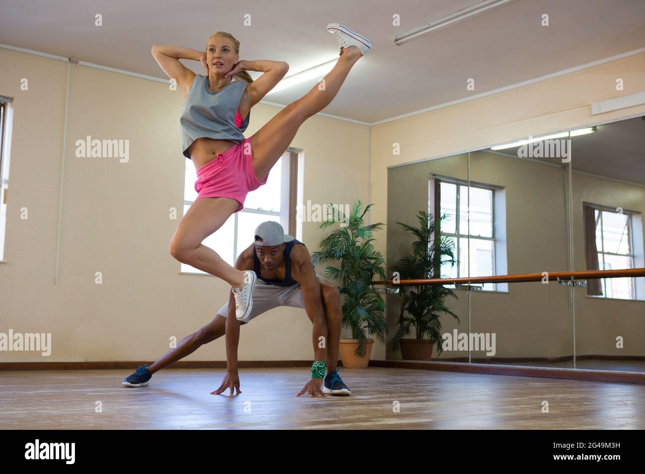 Female dancer with friend jumping in studio Stock Photo
