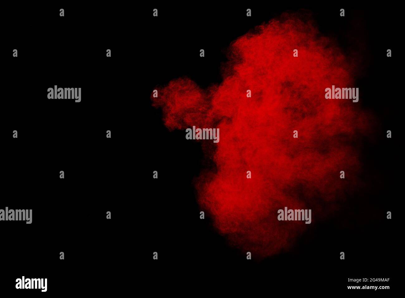 Red powder explosion cloud on black background. Stock Photo