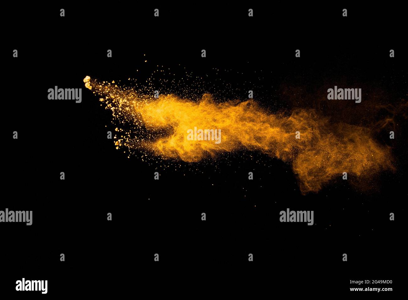 Abstract explosion of orange dust on black background.Freeze motion of orange powder burst. Stock Photo