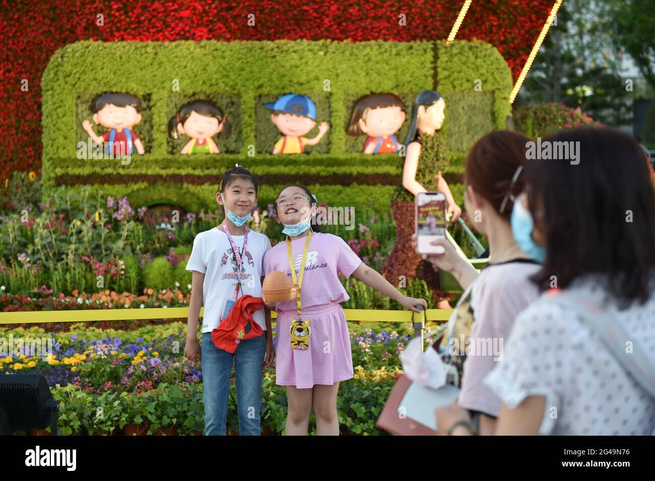 Beijing, China. 19th June, 2021. Children pose for photos with flower decorations set up along Chang'an Avenue in Beijing, capital of China, June 19, 2021. Credit: Chen Zhonghao/Xinhua/Alamy Live News Stock Photo