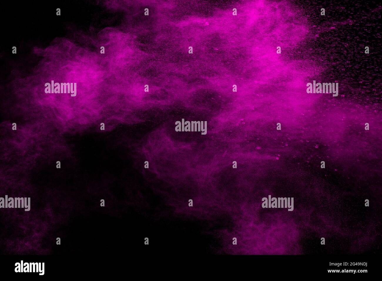 Abstract pink dust particles explosion on black background.Freeze motion of pink powder splash. Stock Photo