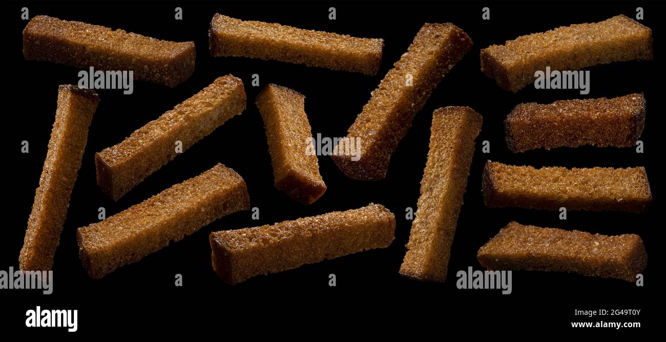 Rye bread croutons on black background, collection Stock Photo