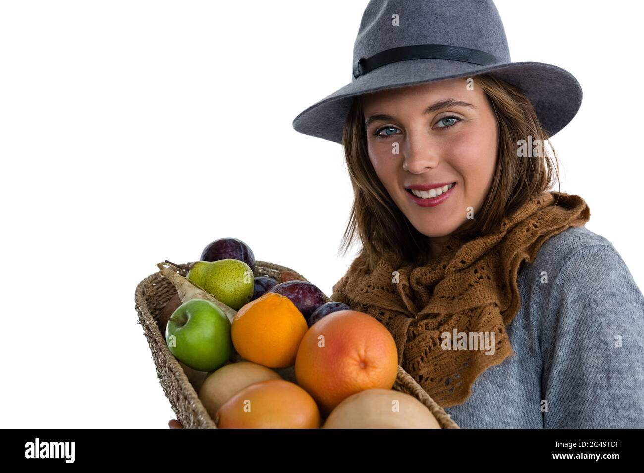 Portrait of smiling woman carrying fruits and vegetables in basket ...