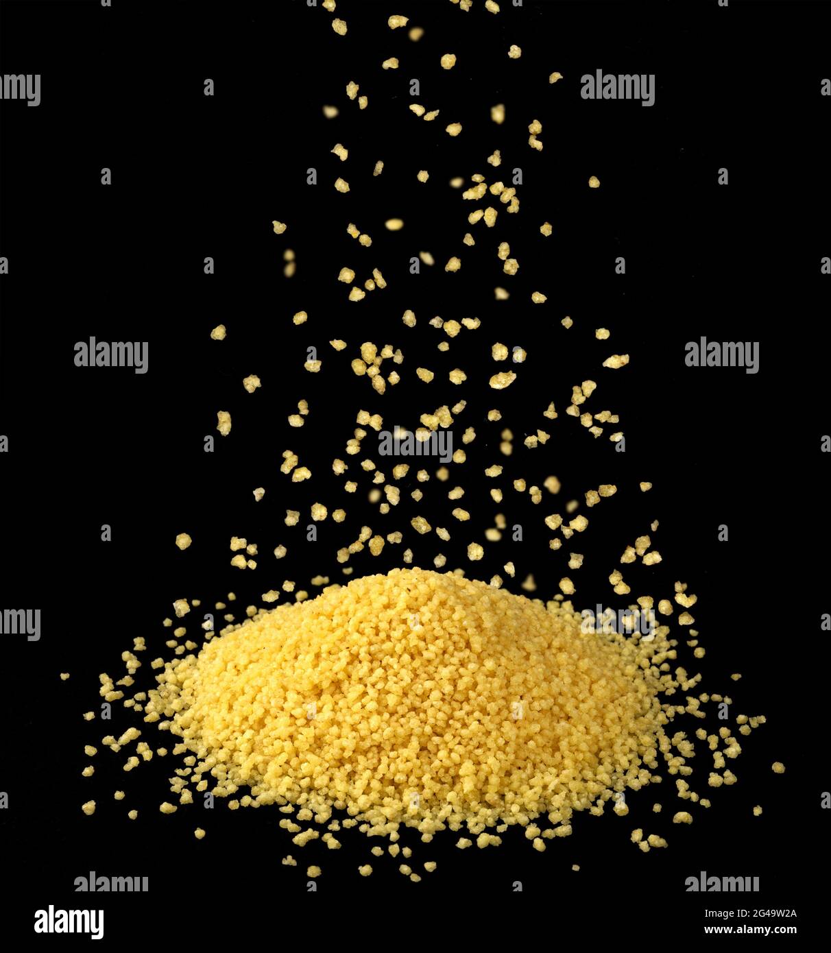 Falling dry couscous groats isolated on black background Stock Photo