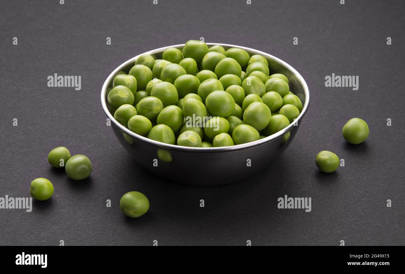 Bowl of fresh green peas on black background Stock Photo