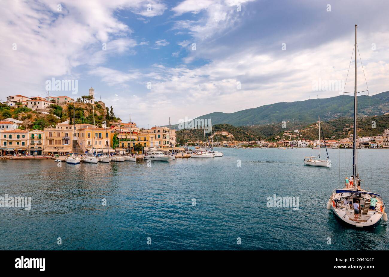 Poros, Greece - April 30 2018: View of the port and the town, with many sailing boats. The town of Galatas, at the Peloponnesean coast, is in the back Stock Photo