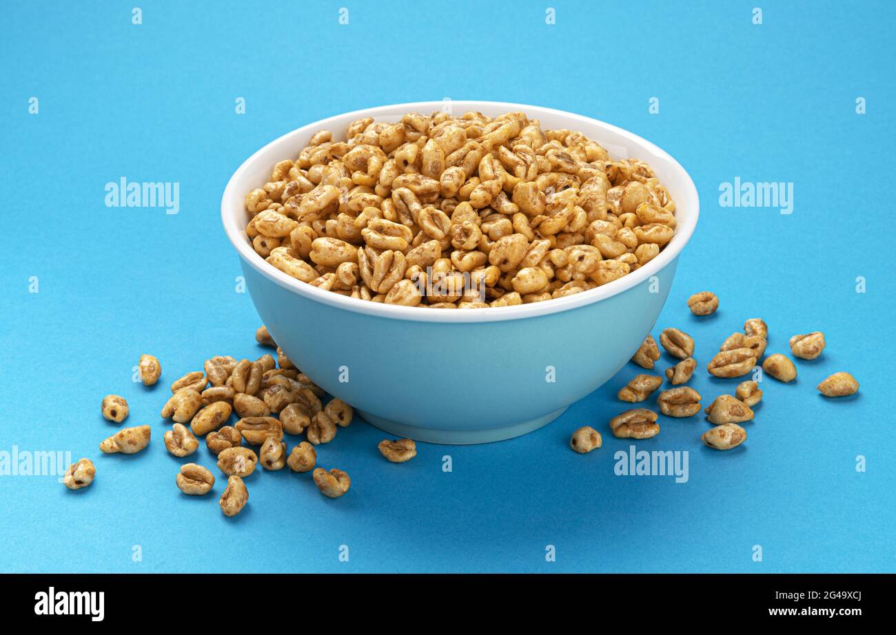 Puffed wheat cereal isolated on blue background Stock Photo