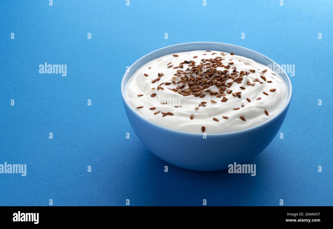 Yogurt with flax seeds isolated on blue background Stock Photo Alamy