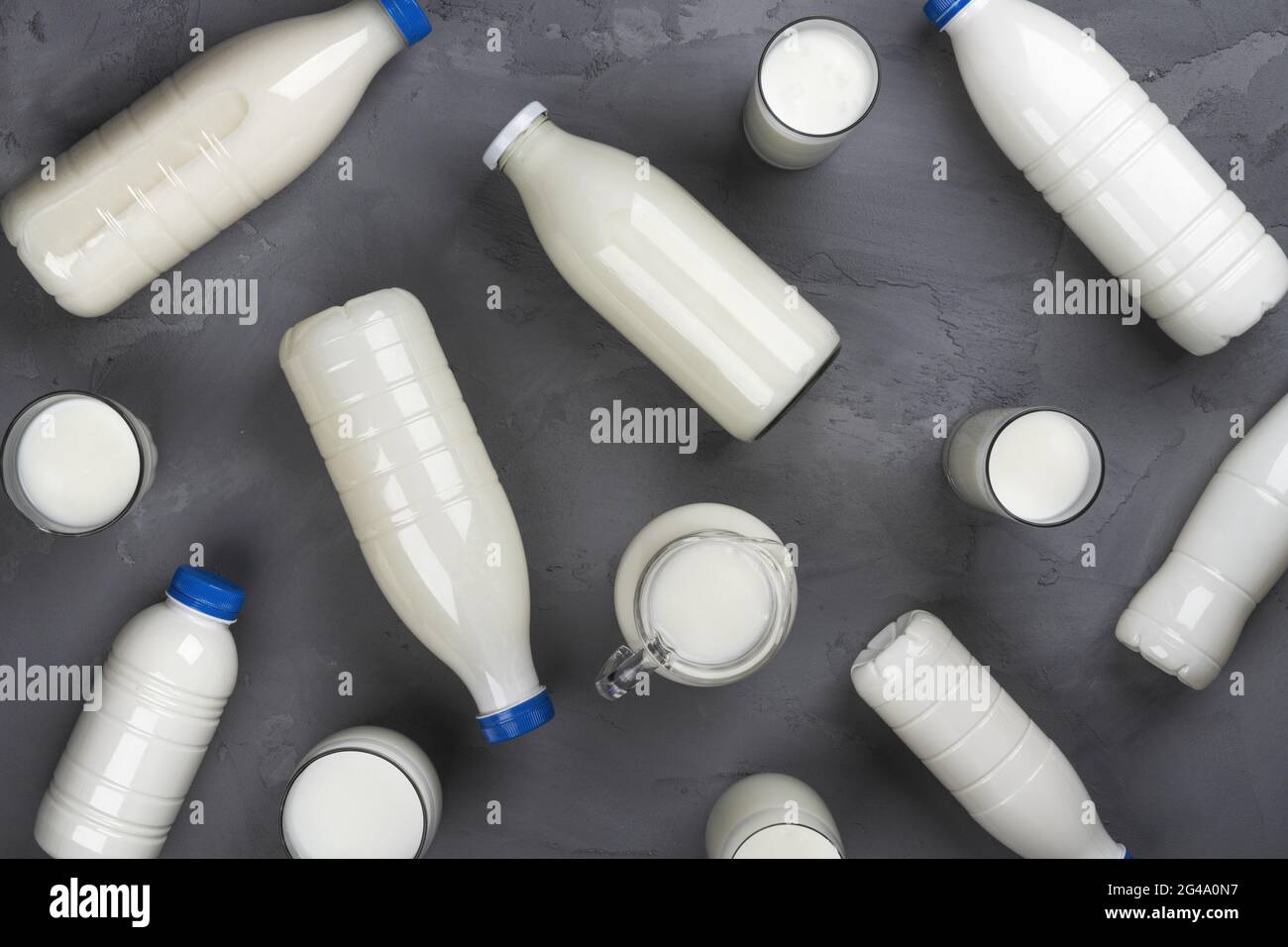 Collection of milk bottles on gray stone background, top view Stock