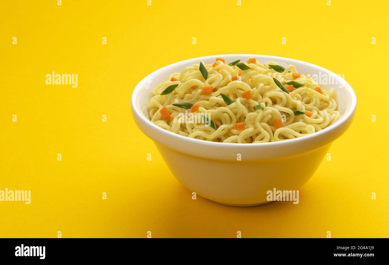 Bowl of instant noodles isolated on yellow background Stock Photo