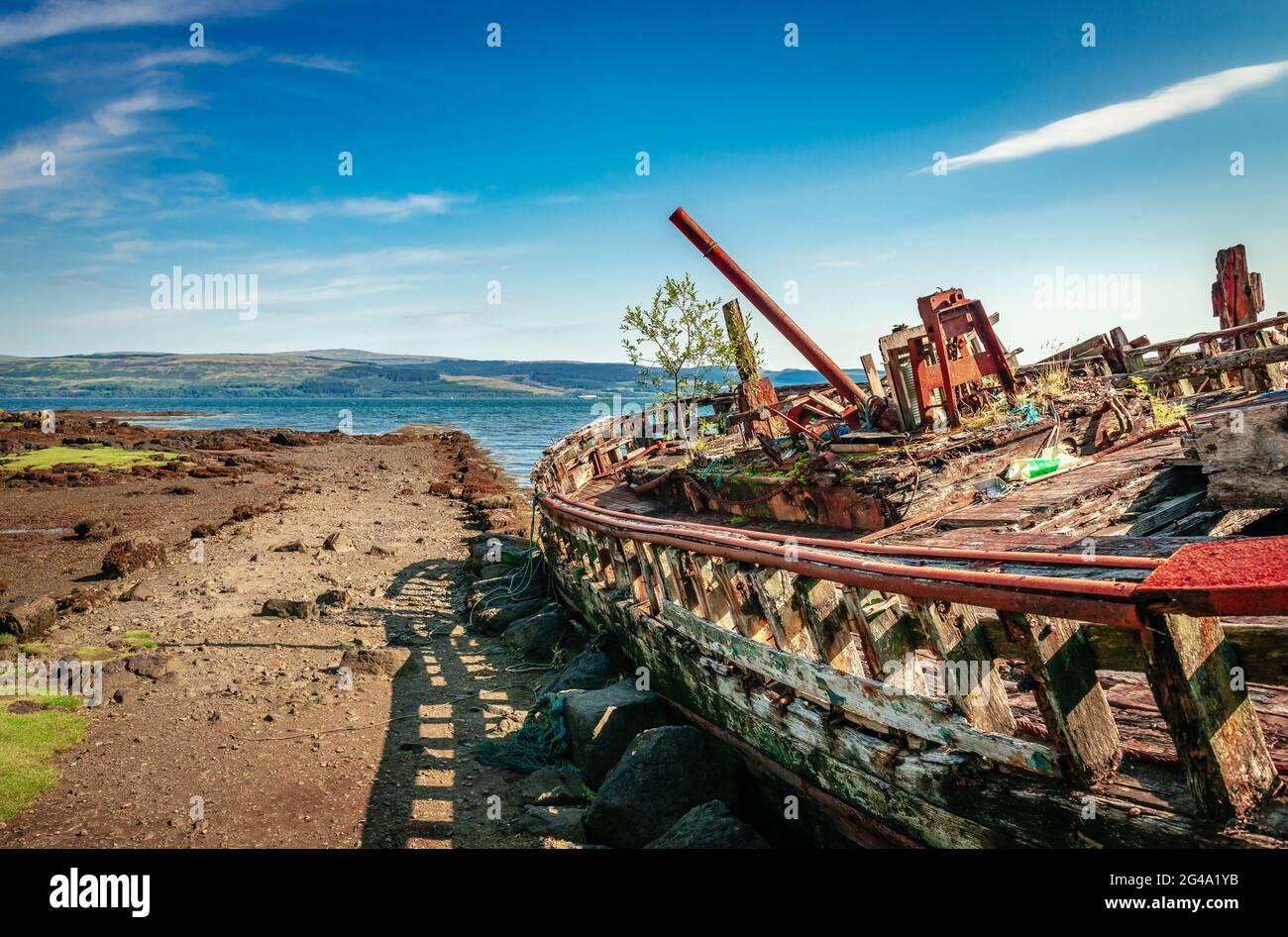 Fishing boat wrecks at Salen, on the Isle of Mull. The Sound of Mull is in the background.  Scotland, August 2019. Stock Photo