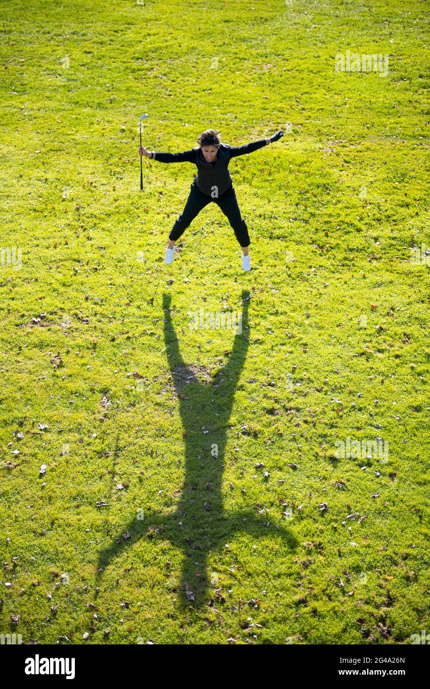 Golfer with Success Holding Golf Club and Ball and Jumping on the Fairway  with Shadow in Switzerland Stock Photo - Alamy