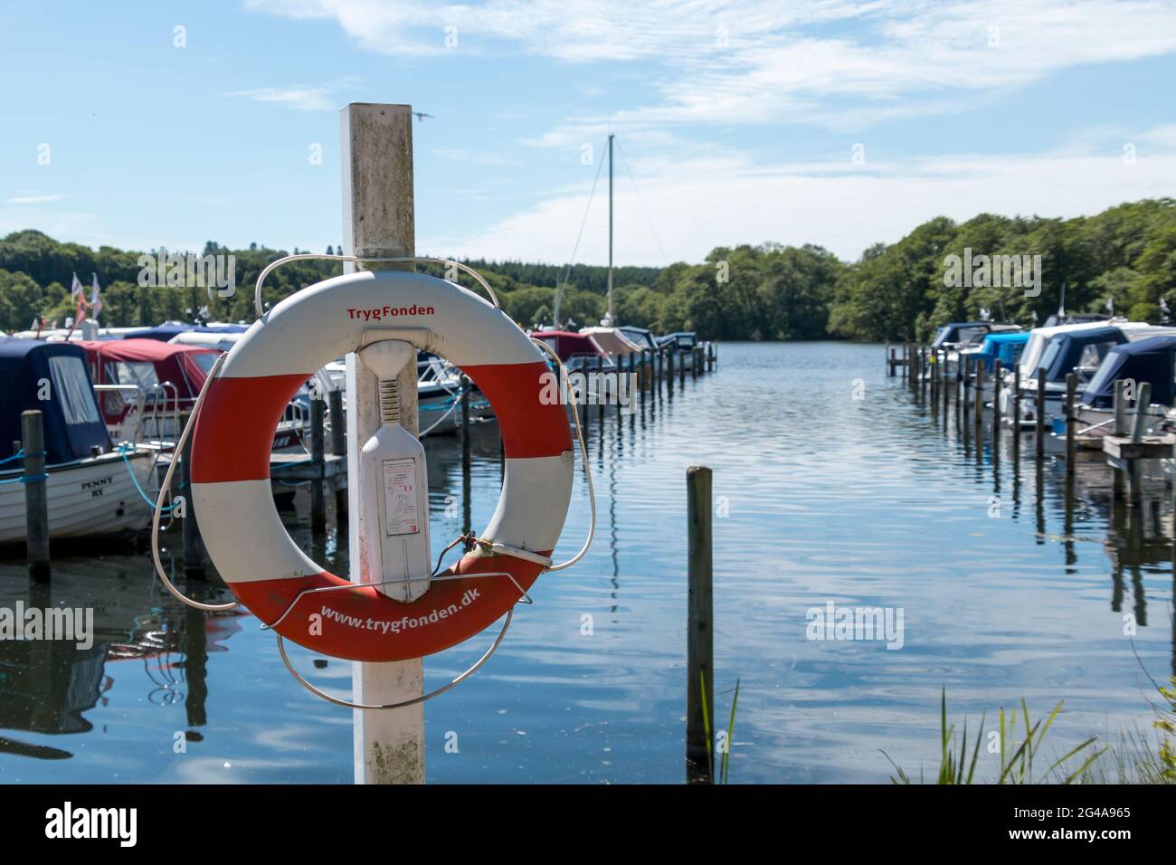 Ry, Denmark - June 16 2021: Ry Marina by Silkeborg, Beautiful marina with both in the background and lifebuoy in the foreground. a nice summer day. Bl Stock Photo