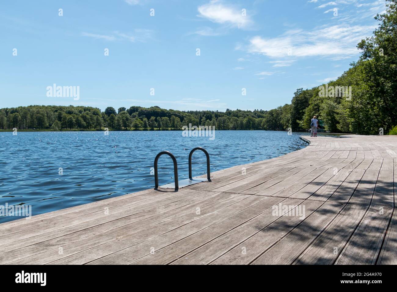 Ry, Denmark - June 16 2021: Bathing bridge by a lake near Silkeborg, Beautiful blue water with forest in the background. Stock Photo