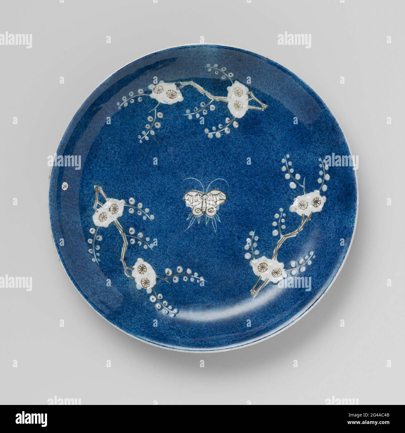 Saucer-Dish With Powder Blue, Prunus Sprays and Butterflies. Dish with  round wall of porcelain, painted in underglaze blue, red and white sludge.  The entire front is covered with bleu poudré (powder blue)