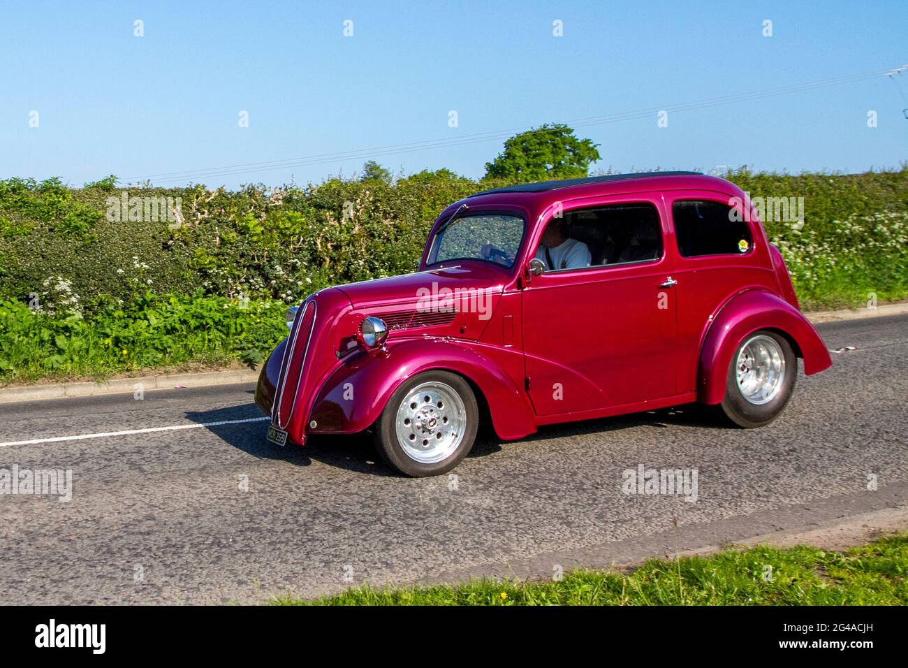 1954 50s fifties red Ford Popular, 3500cc petrol modified Hot Rod, 2dr saloon en-route to Capesthorne Hall classic May car show, Cheshire, UK Stock Photo