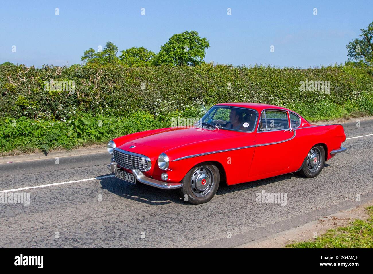 1963 60s sixties red Volvo P1800 2+2, front-engine, rear-drive sports car 1779cc petrol 2dr coupe en-route to Capesthorne Hall classic May car show, Cheshire, UK Stock Photo