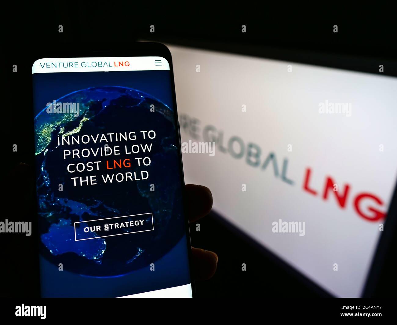 Person holding mobile phone with website of US natural gas company Venture Global LNG Inc. on screen with logo. Focus on center of phone display. Stock Photo