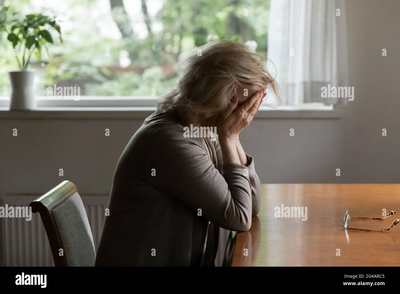 Unhappy mature woman feel depressed alone at home Stock Photo