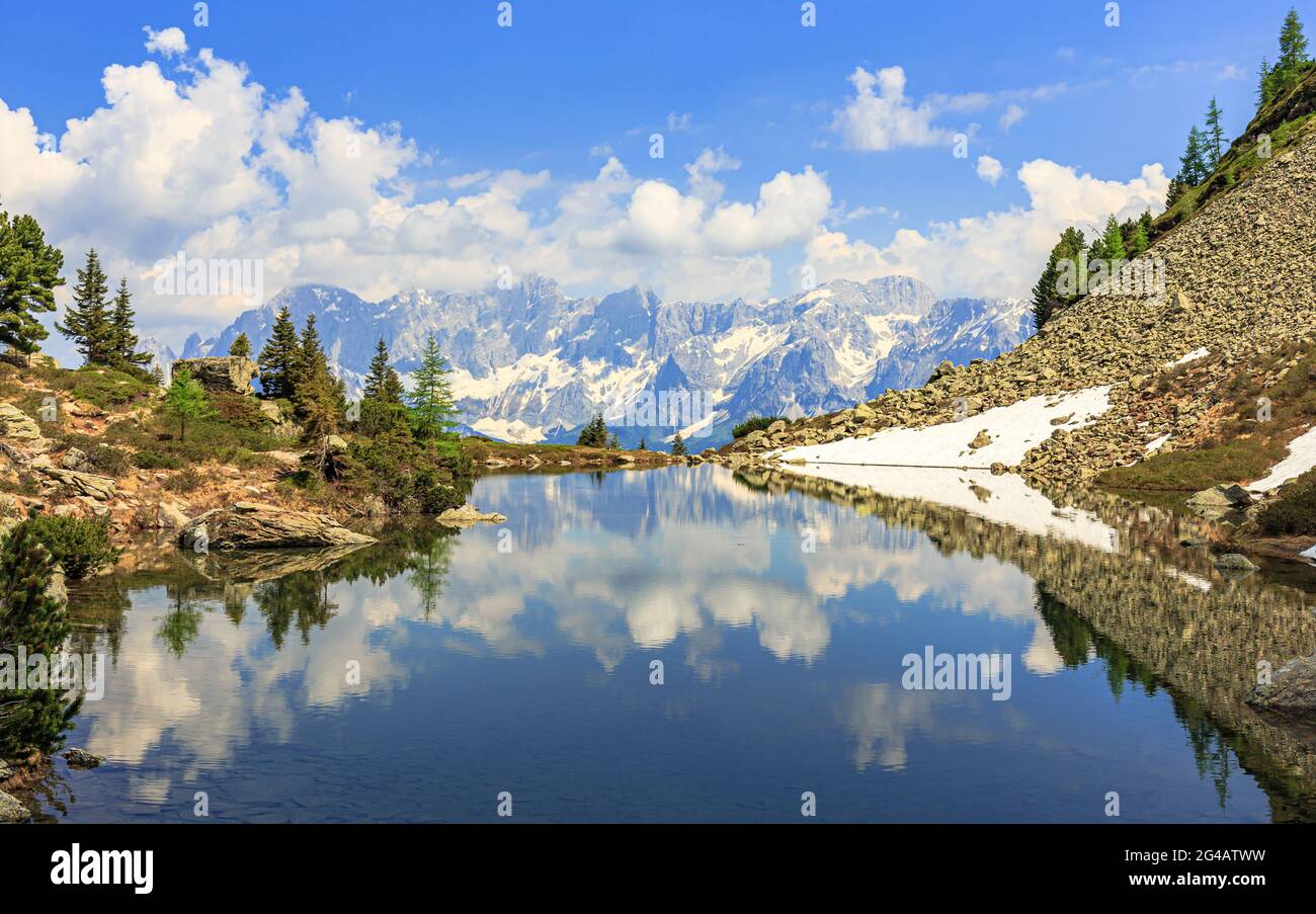 Dachstein mountain range near Schladming with reflection in the mirror lake aka Spiegelsee on Reiteralm Stock Photo