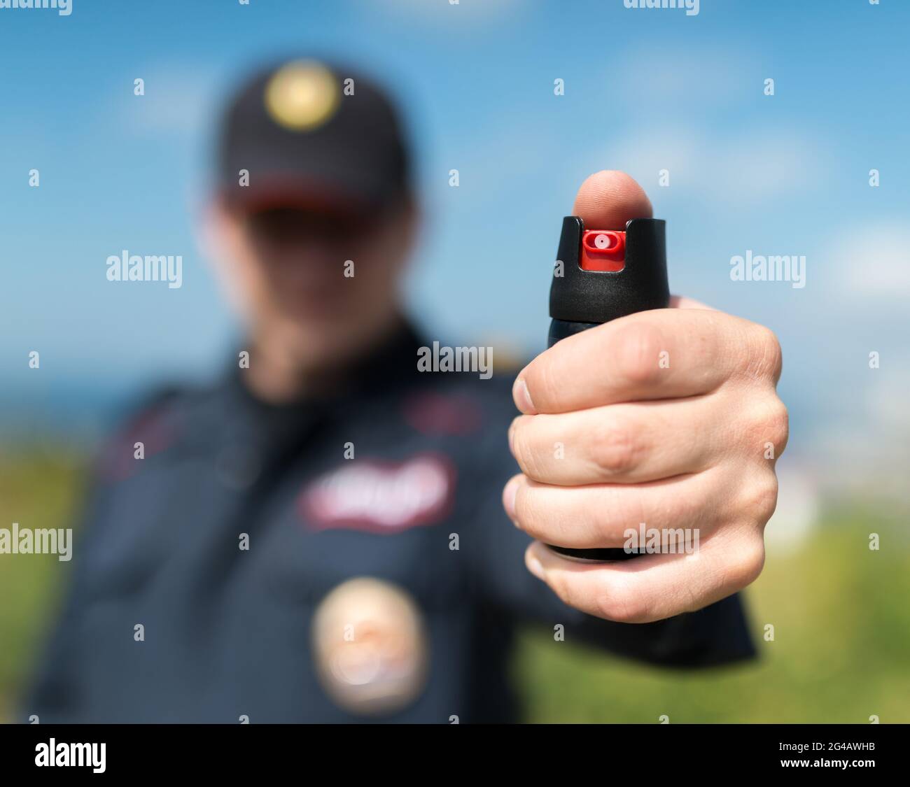 Detail of a police officer holding pepper spray. Selective focus with shallow depth of field. Stock Photo