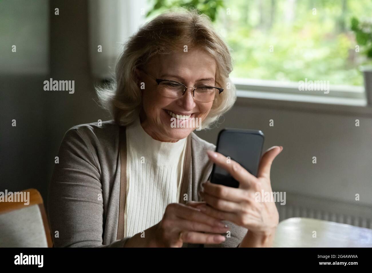 Smiling mature woman have video call on cellphone Stock Photo - Alamy