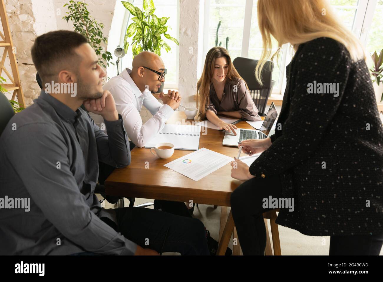 Young men and women, office workers, colleagues working togerther in ...