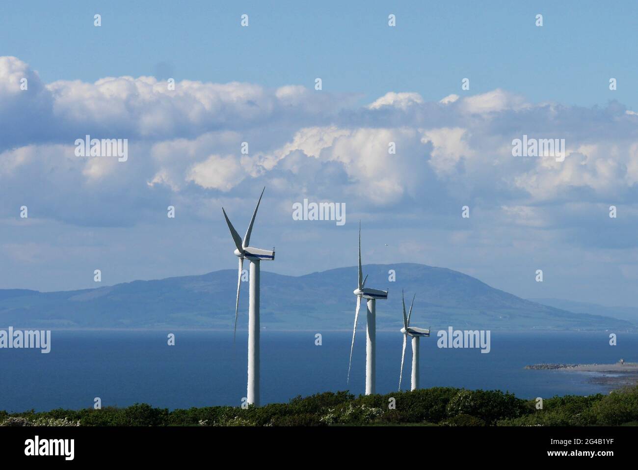 Three Wind Turbines, with the Scottish Coast beyond, Park House Farm, Lowca, Cumbria, England, United Kingdom Stock Photo