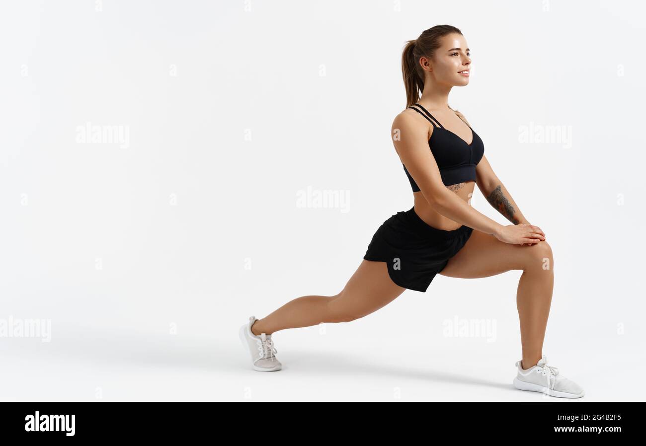 Beautiful female athlete stretching before workout indoors. Sport woman  stretch legs, doing gym exercises alone isolated white background,  silhouette Stock Photo - Alamy