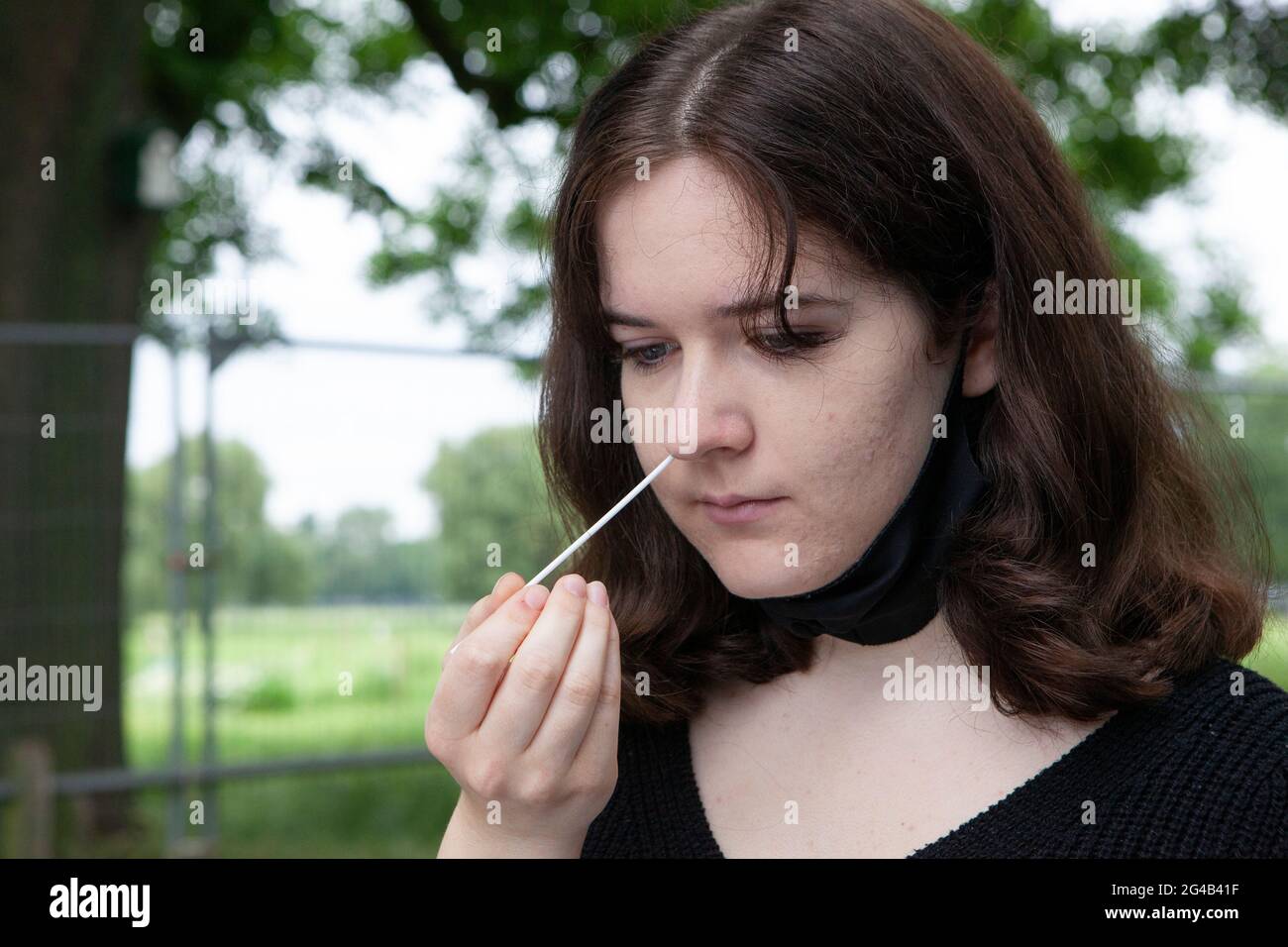 London, UK. 20th June, 2021. An 18 year old performs a PCR test at an outdoor mobile testing centre on Clapham Common. Surge testing has started in Lambeth in response to local rises in cases of the delta variant, part of a possible third wave or coronavirus in England. Credit: Anna Watson/Alamy Live News Stock Photo