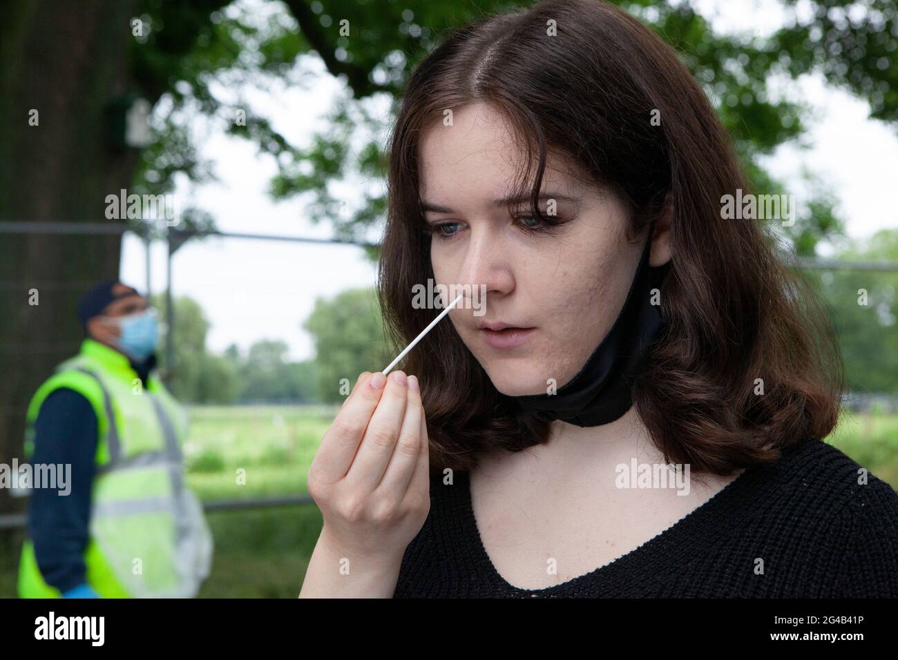 London, UK. 20th June, 2021. An 18 year old performs a PCR test at an outdoor mobile testing centre on Clapham Common. Surge testing has started in Lambeth in response to local rises in cases of the delta variant, part of a possible third wave or coronavirus in England. Credit: Anna Watson/Alamy Live News Stock Photo