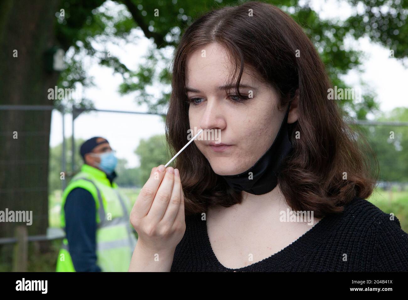 London, UK. 20th June, 2021. An 18 year old performs a PCR test at an outdoor mobile testing centre on Clapham Common. Surge testing has started in Lambeth in response to local rises in cases of the delta variant, part of a possible third wave or coronavirus in England. Credit: Anna Watson/Alamy Live News Stock Photo